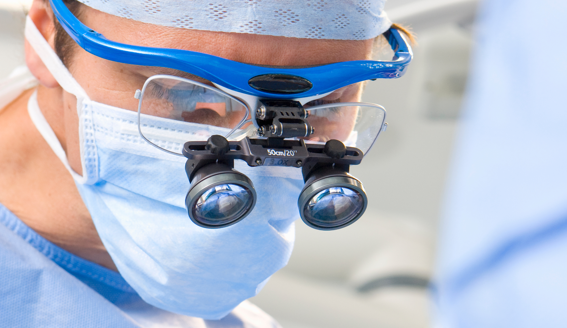 Close-up of a maxillofacial surgeon wearing 3.0x surgical loupes during a zygomatic implant procedure
